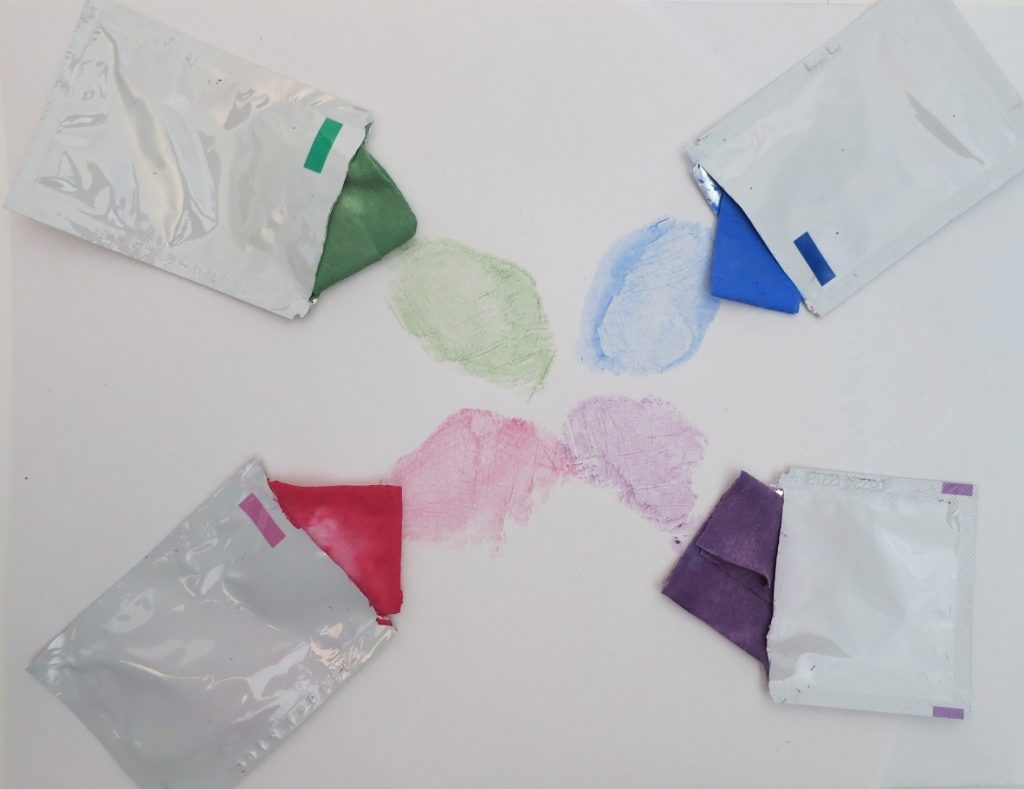 Four Imp Prints Co paint swabs for making baby footprint & hand print keepsakes for parents. They are shown open with the coloured swab poking out.