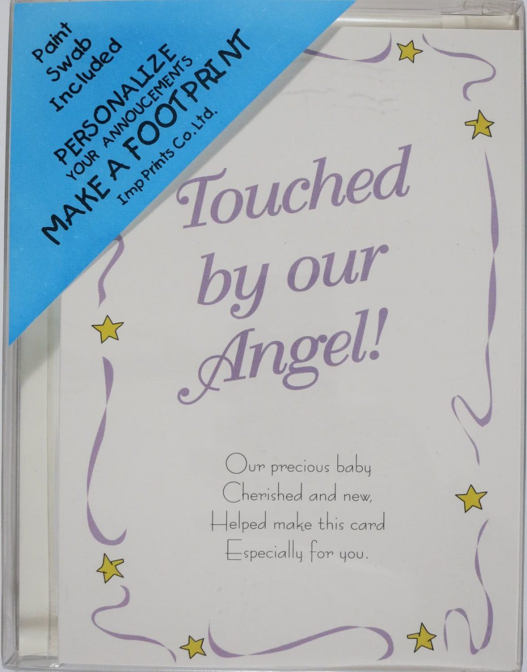 Picture of a plastic box containing Imp Prints Co Angel Birth Announcement Card. Inside a whimsical purple border with yellow stars, it says "Touched by our Angel!" Underneath is a poem "Our precious baby, Cherished and new, Helped make this card, Especially for you.